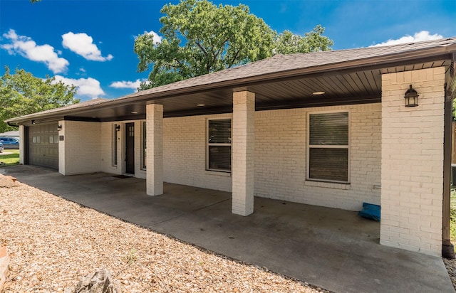1018 Brookhollow Dr, Irving, TX 75061 - back of property with an attached garage, brick siding, and roof with shingles