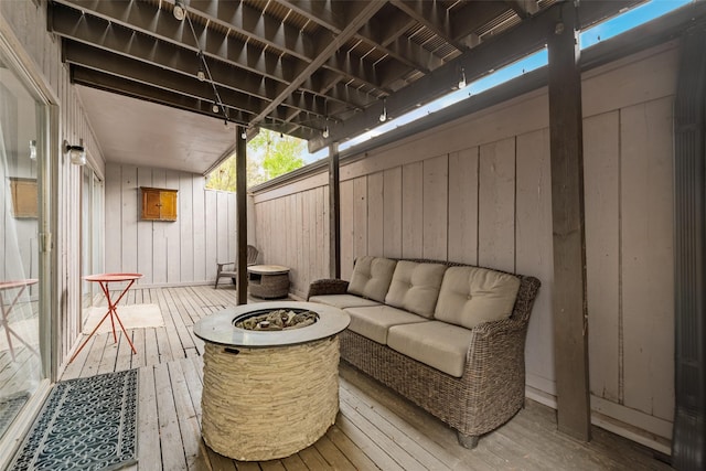 wooden terrace featuring an outdoor fire pit and fence