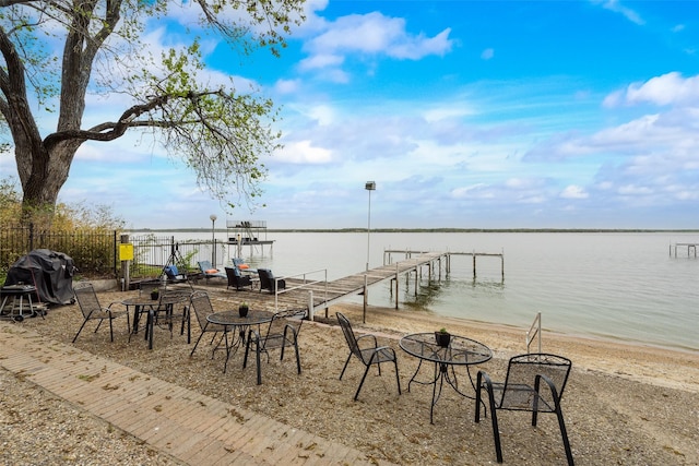 dock area with a water view and fence