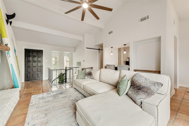 living area with visible vents, a barn door, light tile patterned floors, and a ceiling fan