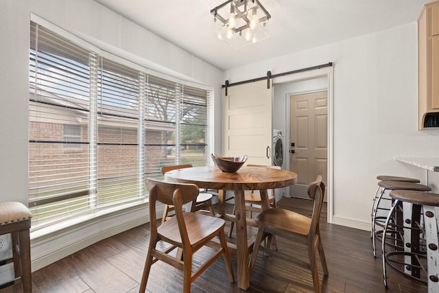 dining space with baseboards, a barn door, and dark wood-style flooring