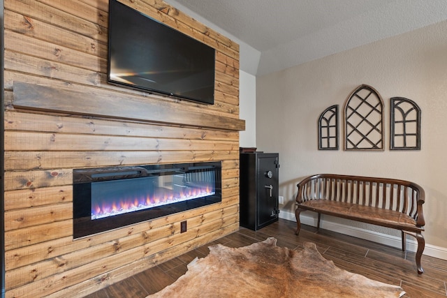 living room with baseboards, a fireplace, and dark wood finished floors