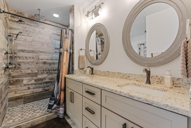 bathroom featuring double vanity, a sink, and tiled shower