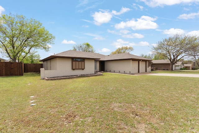 view of front facade featuring fence, an attached garage, concrete driveway, a front yard, and brick siding