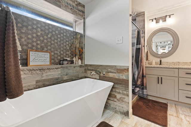 full bathroom with a shower with curtain, a freestanding bath, and vanity
