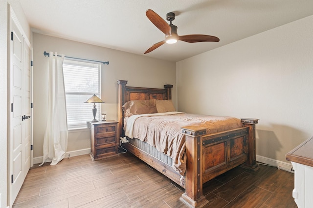 bedroom featuring baseboards, wood finished floors, and a ceiling fan