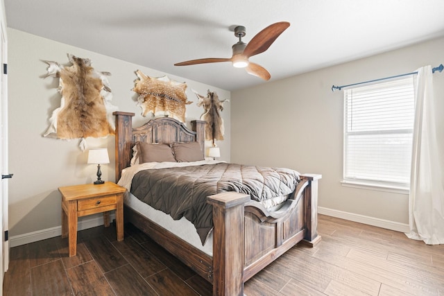 bedroom with baseboards, wood finished floors, and a ceiling fan