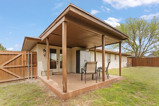 view of patio with a gate, fence, cooling unit, and french doors