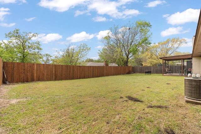 view of yard with a fenced backyard and central AC unit