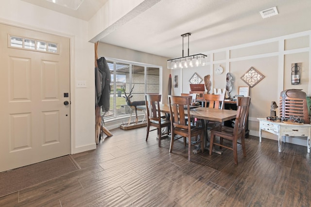 dining area with dark wood-style floors, visible vents, and baseboards
