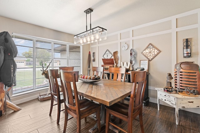 dining space featuring baseboards and wood finished floors