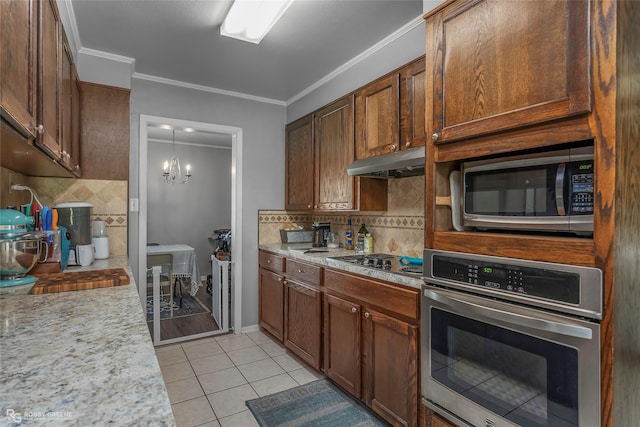 1806 Ray Ave, Bossier City, LA 71112 - kitchen with light tile patterned floors, under cabinet range hood, crown molding, stainless steel appliances, and decorative backsplash