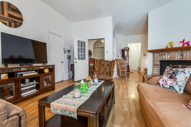 living room featuring light wood-style flooring and a fireplace