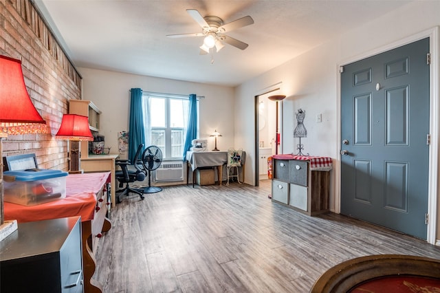 home office featuring a wall mounted AC, wood finished floors, and ceiling fan