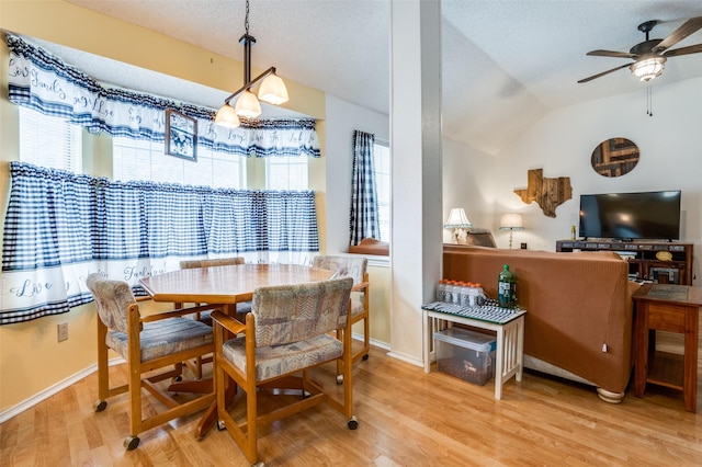 dining area with wood finished floors, vaulted ceiling, a ceiling fan, and plenty of natural light