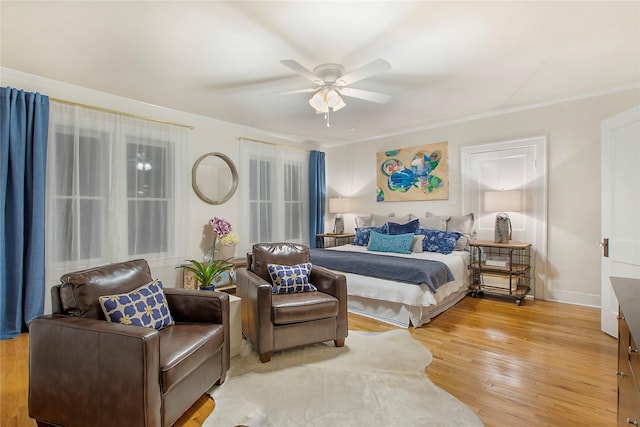bedroom with ornamental molding, baseboards, ceiling fan, and light wood-type flooring