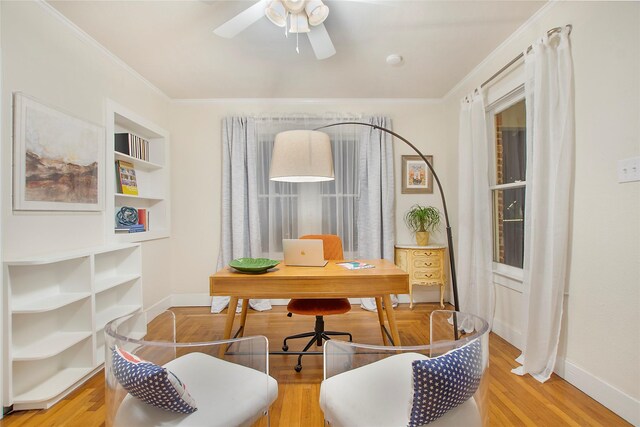 office featuring light wood finished floors, baseboards, crown molding, and ceiling fan