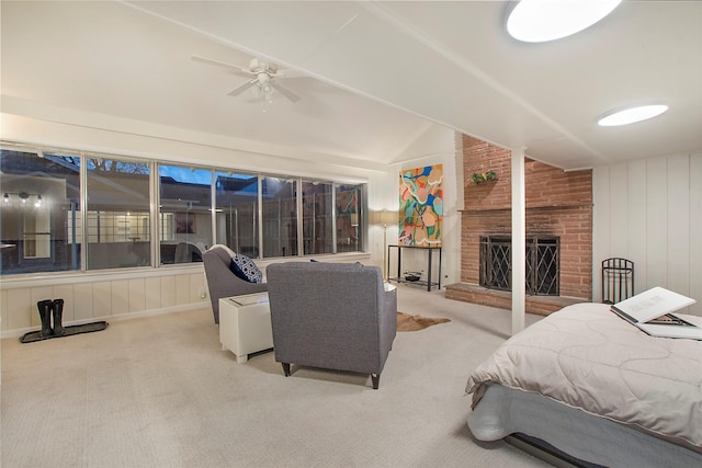 carpeted bedroom featuring a ceiling fan, lofted ceiling, and a fireplace