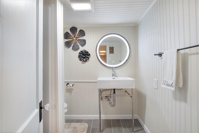 bathroom featuring baseboards, wood finished floors, toilet, and a sink