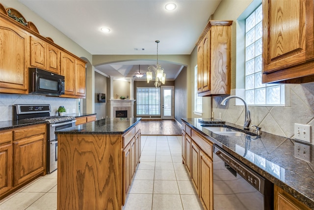 2212 Stone Creek Dr, Mckinney, TX 75072 - kitchen with stainless steel appliances, a sink, a kitchen island, a chandelier, and brown cabinetry