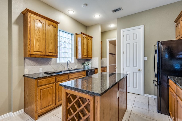 2212 Stone Creek Dr, Mckinney, TX 75072 - kitchen with a sink, black appliances, brown cabinets, tasteful backsplash, and dark stone counters