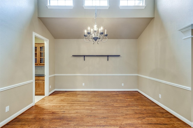 2212 Stone Creek Dr, Mckinney, TX 75072 - unfurnished room featuring a chandelier, wood finished floors, baseboards, and vaulted ceiling