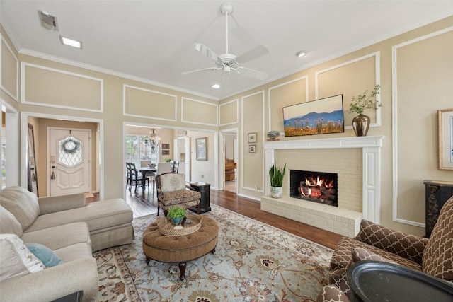 2002 Thames Dr, Arlington, TX 76017 - living room with a decorative wall, crown molding, a ceiling fan, wood finished floors, and a brick fireplace