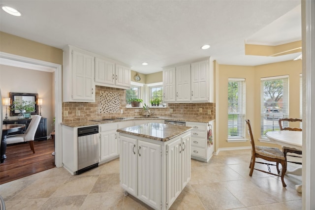 2002 Thames Dr, Arlington, TX 76017 - kitchen with decorative backsplash, white cabinets, a center island, light stone countertops, and recessed lighting