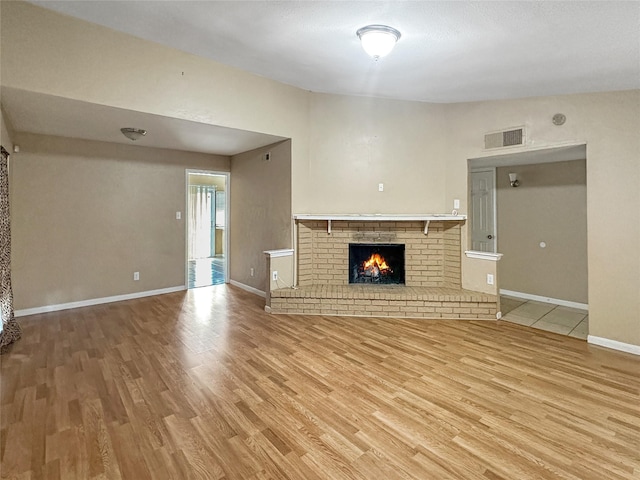 411 Mckinley St, Cedar Hill, TX 75104 - unfurnished living room with wood finished floors, baseboards, and a brick fireplace