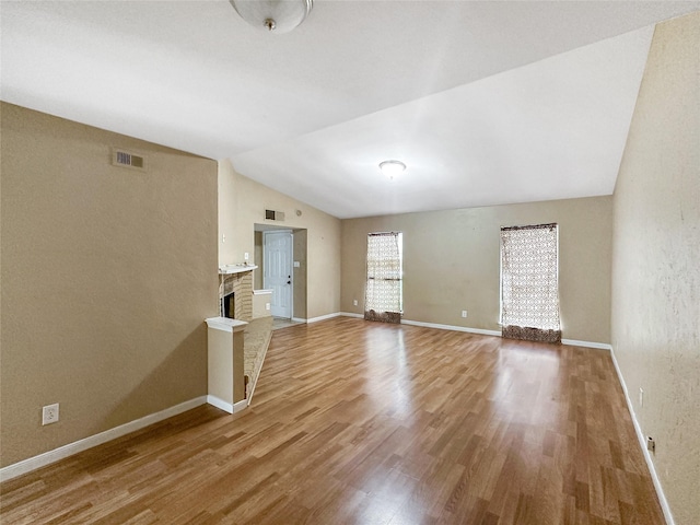411 Mckinley St, Cedar Hill, TX 75104 - spare room with vaulted ceiling, light wood-type flooring, a brick fireplace, and baseboards
