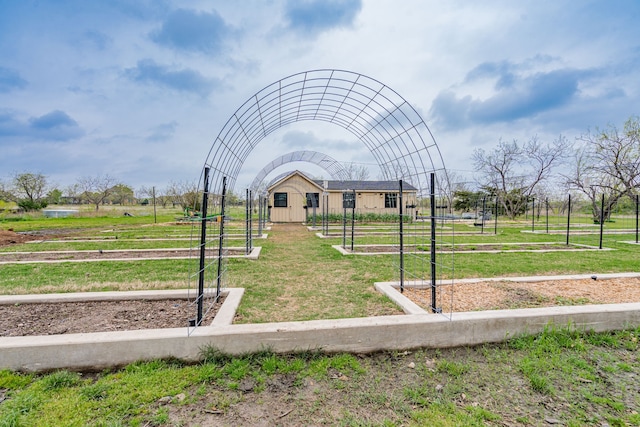 view of home's community with an outdoor structure, fence, and a lawn