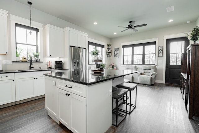kitchen with visible vents, stainless steel fridge, ceiling fan, dark wood-type flooring, and a sink