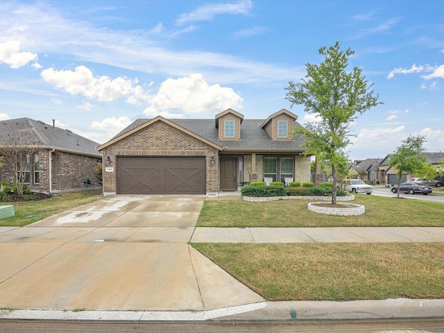 view of front of property with driveway, brick siding, a garage, a shingled roof, and a front yard