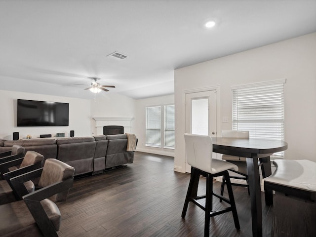 living room with recessed lighting, dark wood finished floors, visible vents, a ceiling fan, and a fireplace