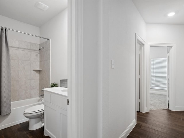 full bathroom with shower / bath combo with shower curtain, wood finished floors, vanity, and toilet