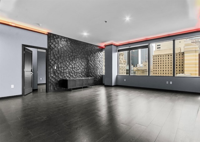 1200 Main St Unit 1511, Dallas, TX 75202 - unfurnished room featuring baseboards, a fireplace, an accent wall, and wood finished floors