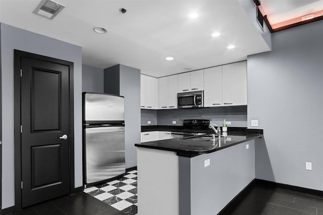 1200 Main St Unit 1511, Dallas, TX 75202 - kitchen featuring visible vents, a peninsula, dark countertops, stainless steel appliances, and white cabinets