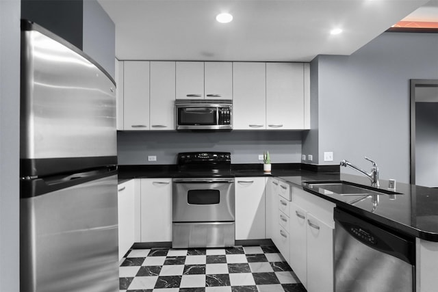 1200 Main St Unit 1511, Dallas, TX 75202 - kitchen with a sink, a peninsula, stainless steel appliances, white cabinets, and dark countertops