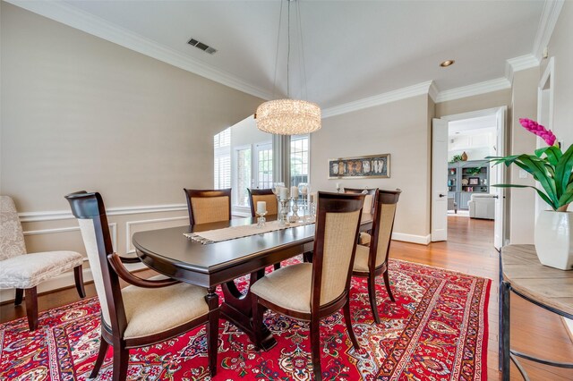 4816 Cape Coral Dr, Dallas, TX 75287 - dining space with a wainscoted wall, visible vents, ornamental molding, wood finished floors, and a notable chandelier