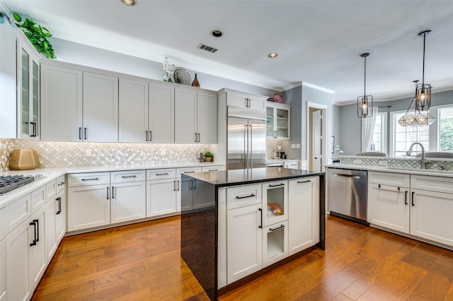 4816 Cape Coral Dr, Dallas, TX 75287 - kitchen featuring dark wood-style flooring, a sink, ornamental molding, and appliances with stainless steel finishes