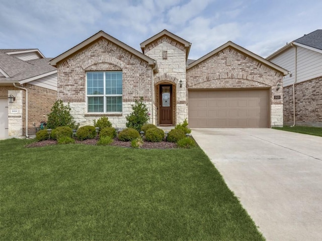 french country style house with concrete driveway, an attached garage, stone siding, and a front lawn