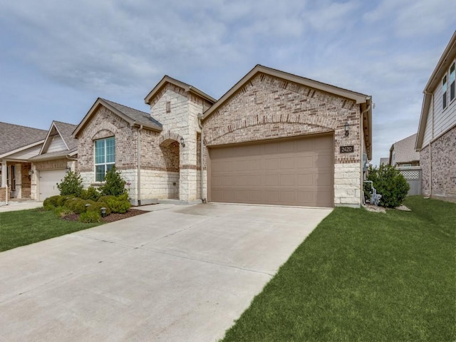 french provincial home featuring an attached garage, concrete driveway, a front lawn, and stone siding