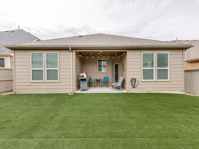 rear view of property featuring a fenced backyard, a patio, and a yard