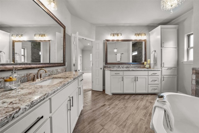 12756 Aspen Springs Ln, Fort Worth, TX 76052 - full bathroom featuring a sink, wood finished floors, two vanities, and a freestanding bath