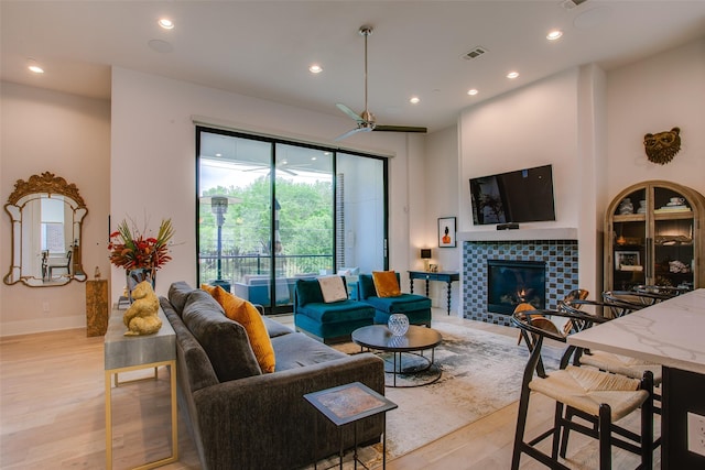 living room with visible vents, light wood finished floors, a fireplace, ceiling fan, and recessed lighting
