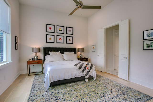 bedroom featuring baseboards, light wood-style floors, and ceiling fan