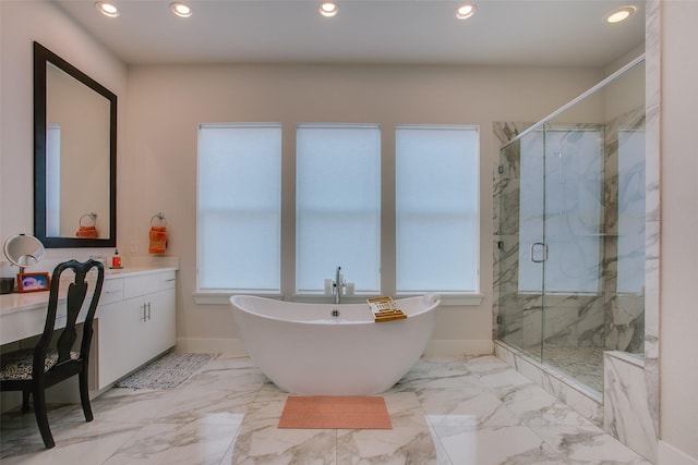 bathroom with marble finish floor, a soaking tub, and plenty of natural light