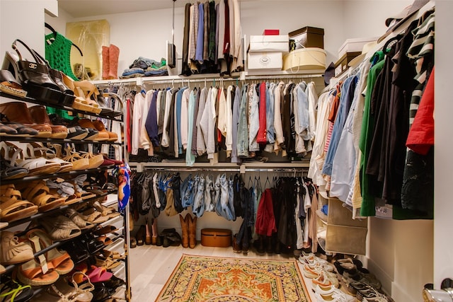 walk in closet with wood finished floors