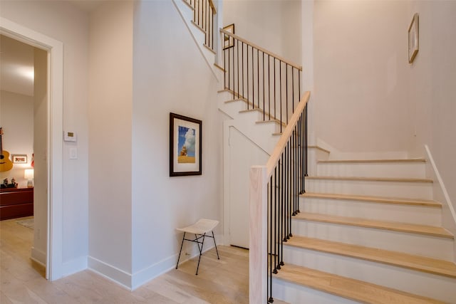 staircase with baseboards and wood finished floors