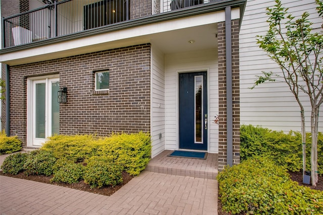 view of exterior entry with brick siding